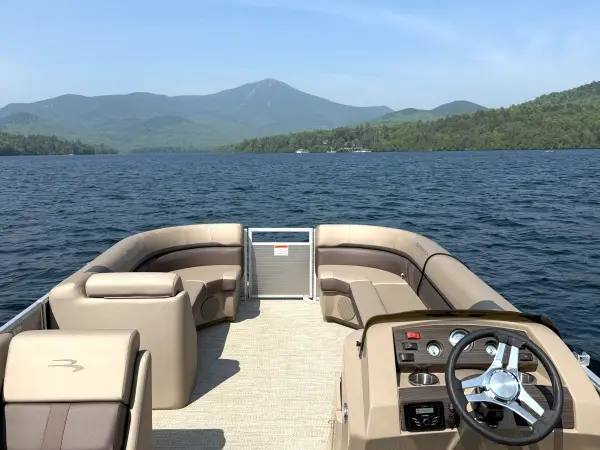 A view of a brown and caramel colored pontoon boat as though you are captaining
