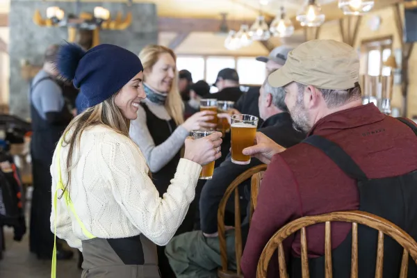 A group of people cheers drinks at a bar in winter.