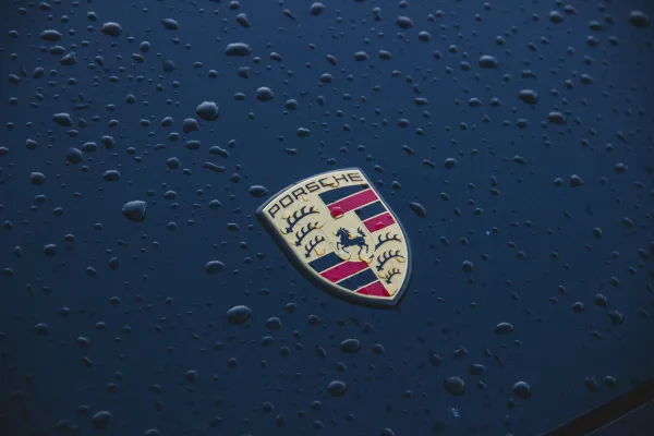 Porche logo on black car with water droplets