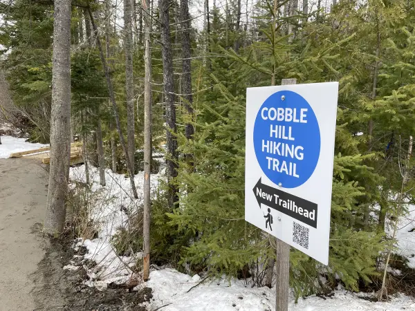 A blue and white sign for the new Cobble Hill Hiking Trail.