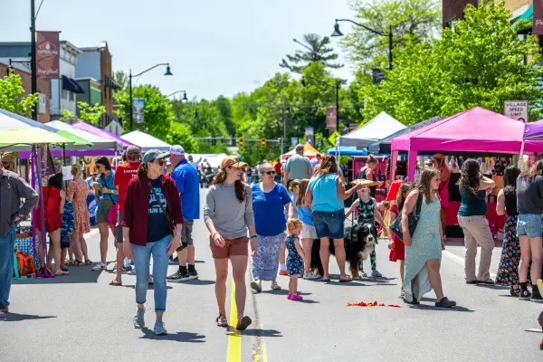 A crowd of people enjoying an event during a sunny day.