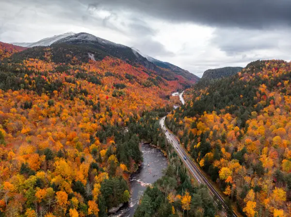 A fall aerial view of a mountain road between mountains