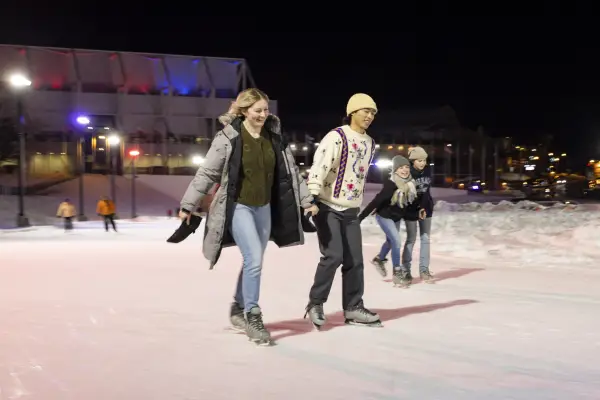 A couple skates at night on the Lake Placid Speed Skating Oval