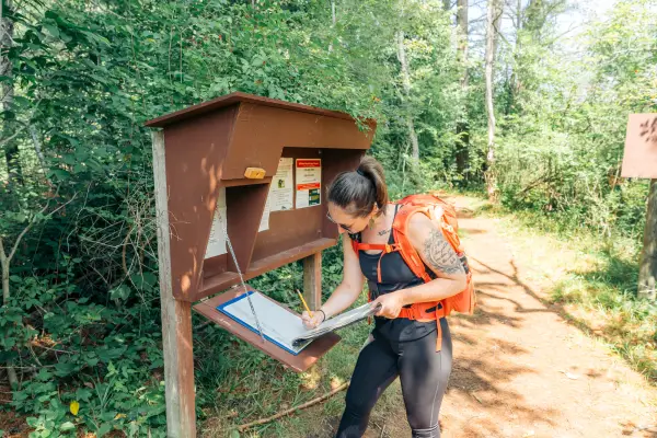 Hiker signs in at Rooster Comb trail register