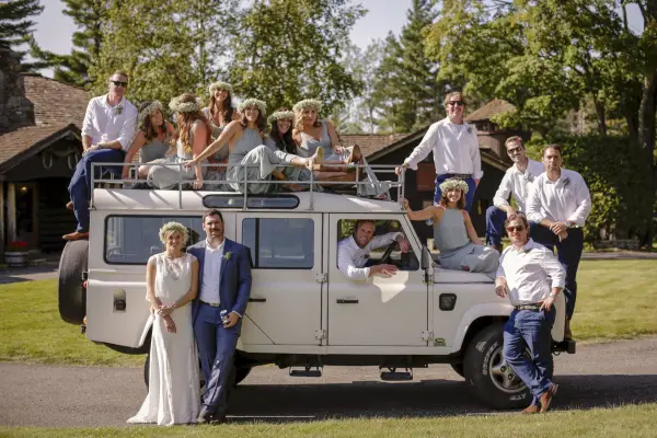 Wedding party posed around an antique safari truck
