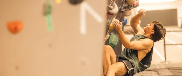 Person seen climbing on bouldering wall at Mt Van Hoevenberg indoor climbing gym
