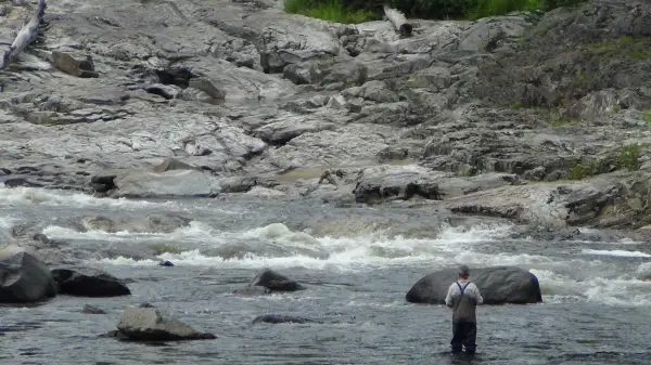 A fly fisher in a rocky creek