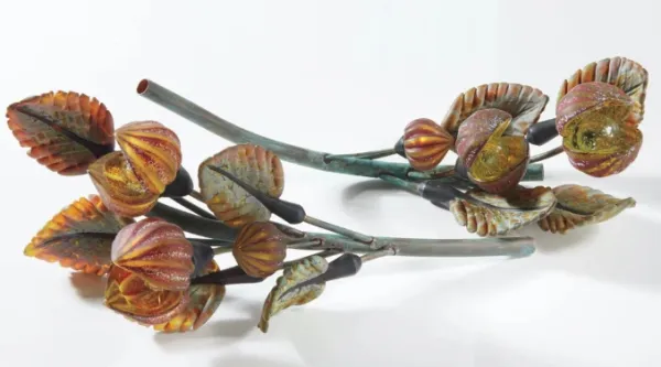 Two flowering branches made of unknown material lie on white surface faced in opposing directions