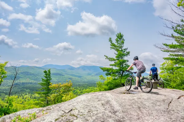 Two mountain bikers hang out at an open summit