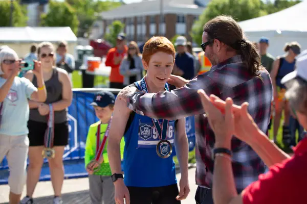 A father puts a finisher medal on this sun