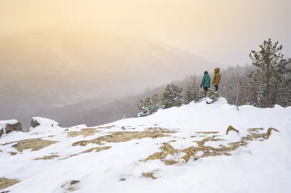 Two people on an open snowy summit
