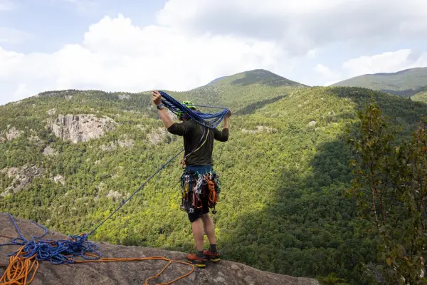 Man nests ropes to prepare for rock climbing