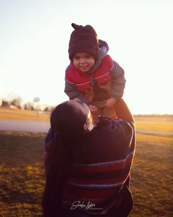 mother lifting her happy child in the air.