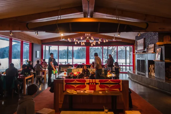 Great room of Lake House in Lake Placid in winter with families mingling near fireplace