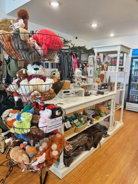 Stuffed animals, stickers and cards and various other items on shelves and in baskets. 