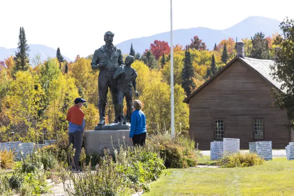 Two people look at a metal statue of John Brown