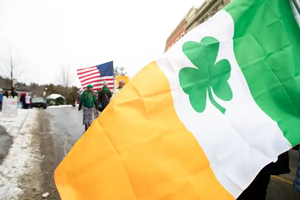 And Irish flag with a clover flown in front of an American flag