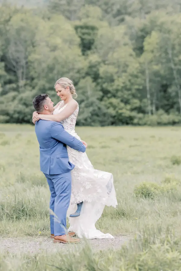 Groom holds bride in the air and spins