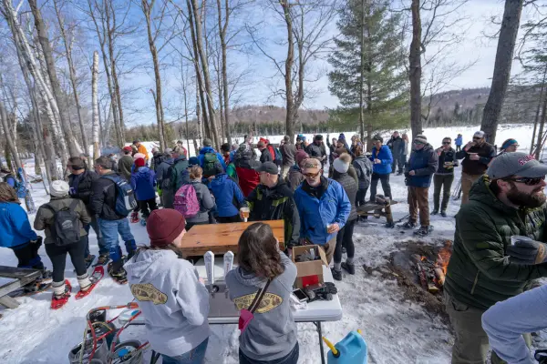 Cross-country skiers getting beer along a trail. 