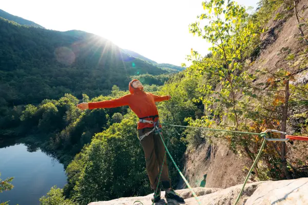 A climber celebrates with outstretched arms after a pitch
