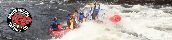 Paddles up overhead while hitting the white water