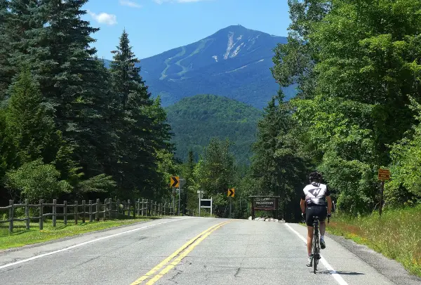 Cyclist on road with Whiteface Mountain in distance