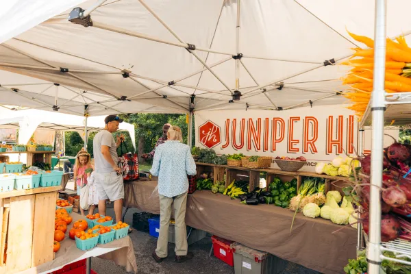 A couple shops at a local produce stand. 