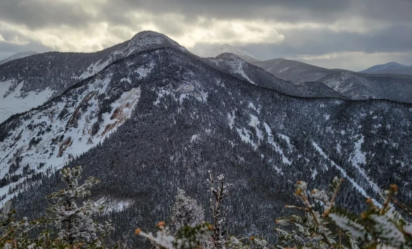 View of a tall mountain with rock slides covered in snow