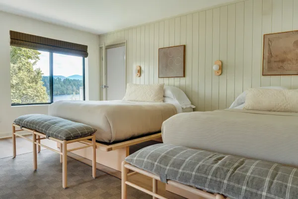 A two queen room at Laurel Lake Placid with mint walls, light wood and view of the mountains