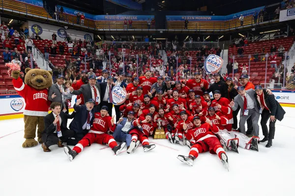 The image captures a close-up of hands reaching out, wearing red hockey gloves. 