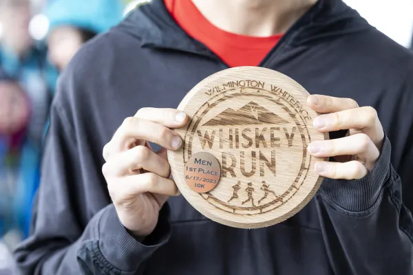 Racer holds up Whiskey Run plaque