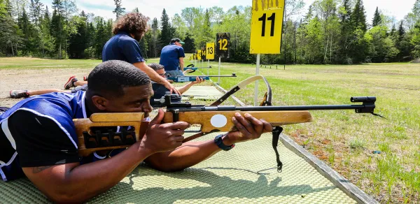 visitors trying biathlon rifles at the biathlon experience