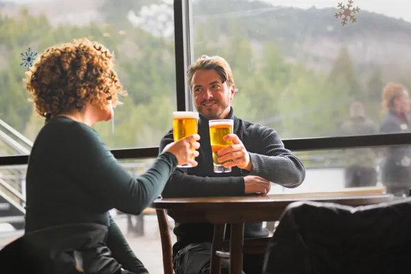 A couple toasting with beverages at Whiteface Mountain.