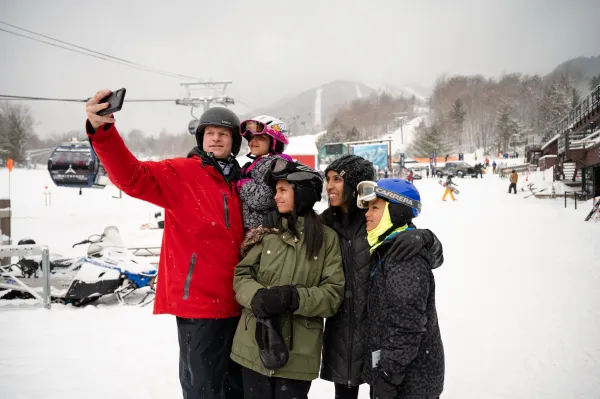 A family takes a photo together in ski gear. 