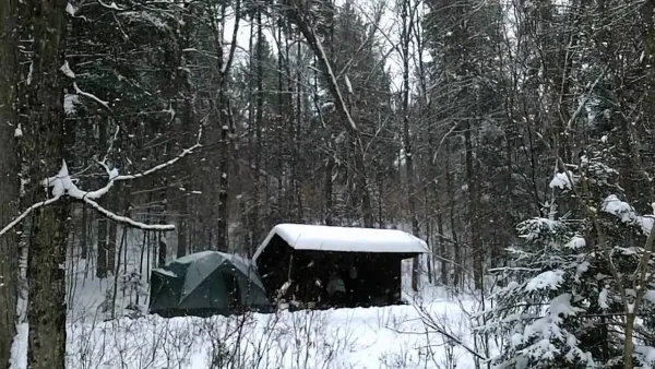 Winter camping set up by a lean to
