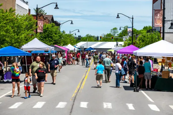 A crowd of people enjoying an event during a sunny day.