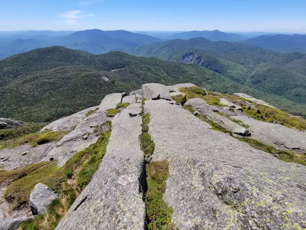 A rocky summit with a view of other tree-covered mountains