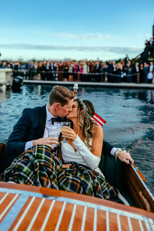 A bride and groom ride into the sunset on a Chris Craft wooded boat