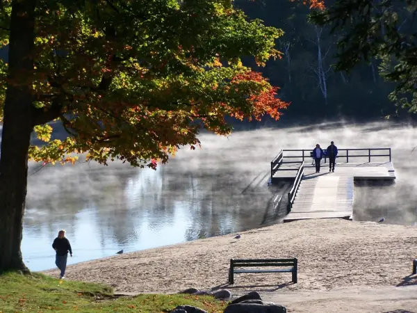 Some people on a dock with mist rising from the water