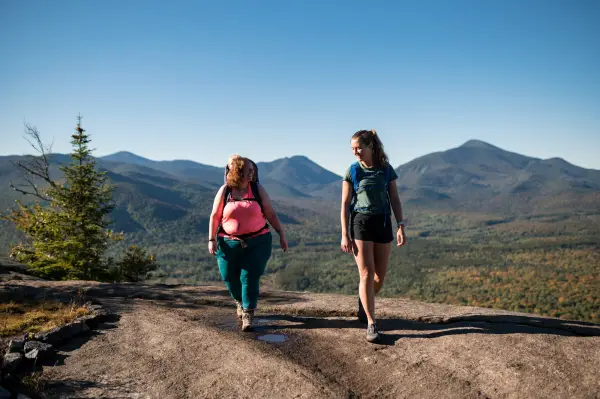 Two hikers on a rocky summit ridge