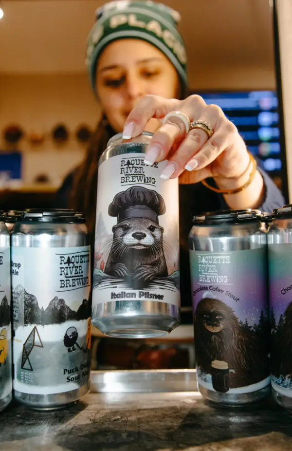 A woman restocking the beer fridge with cans