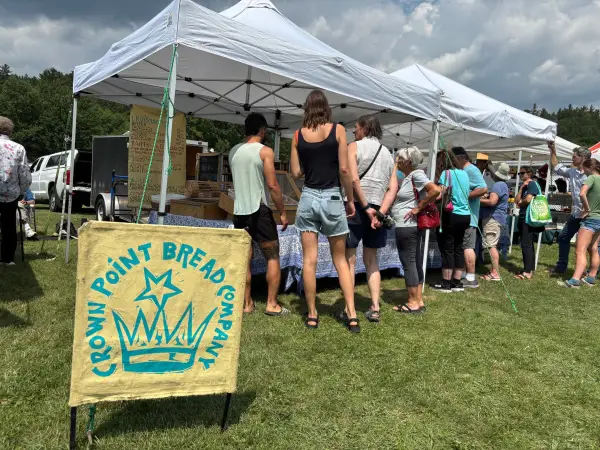 The line of shoppers look into the tent for Crown Point Break Company