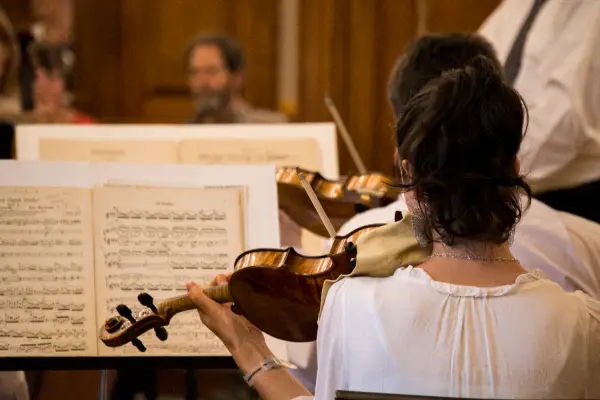 Woman reads music while playing violin
