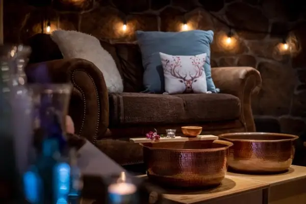 Luxurious blue chair with comfy throw pillow and blanket