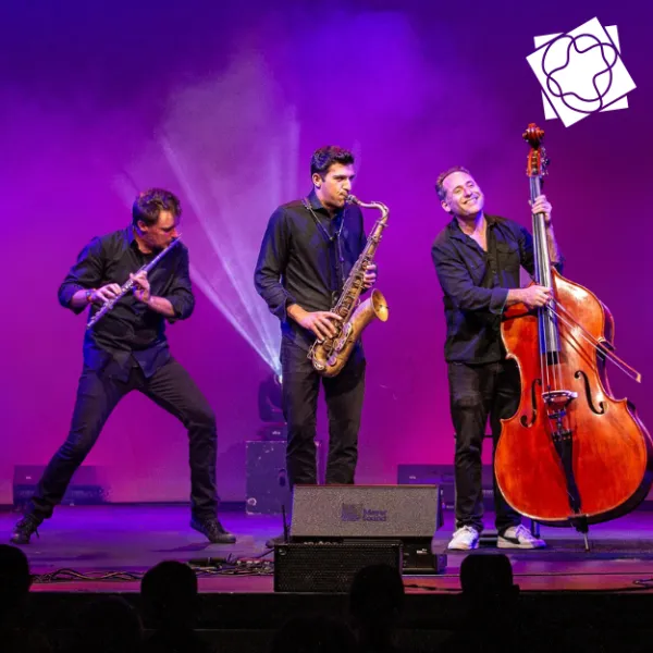 Trio of musicians playing flute, saxaphone, and stand-up bass on a stage