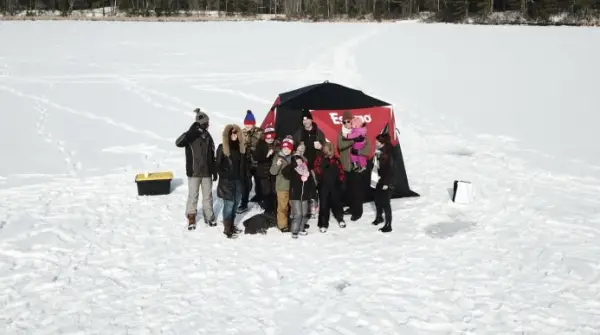Family on the ice next to shanty
