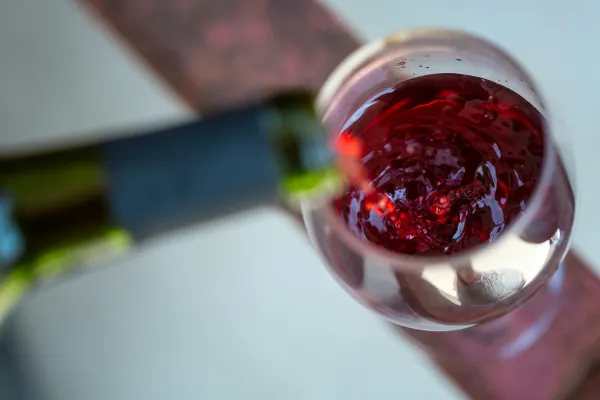 Stock image of red wine being poured from bottle to glass