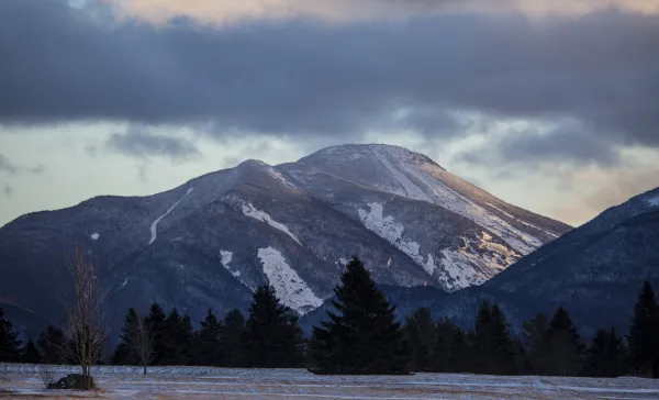 Mountain range covered in light snow and field covered in light snow