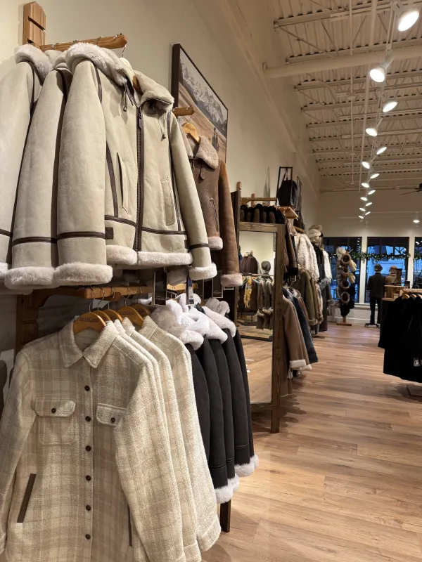 Coats on display in the deep storefront of Overland Lake Placid