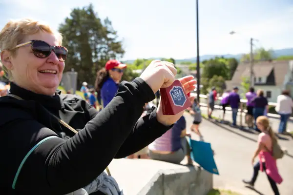 Fan rings a cowbell as athletes run by